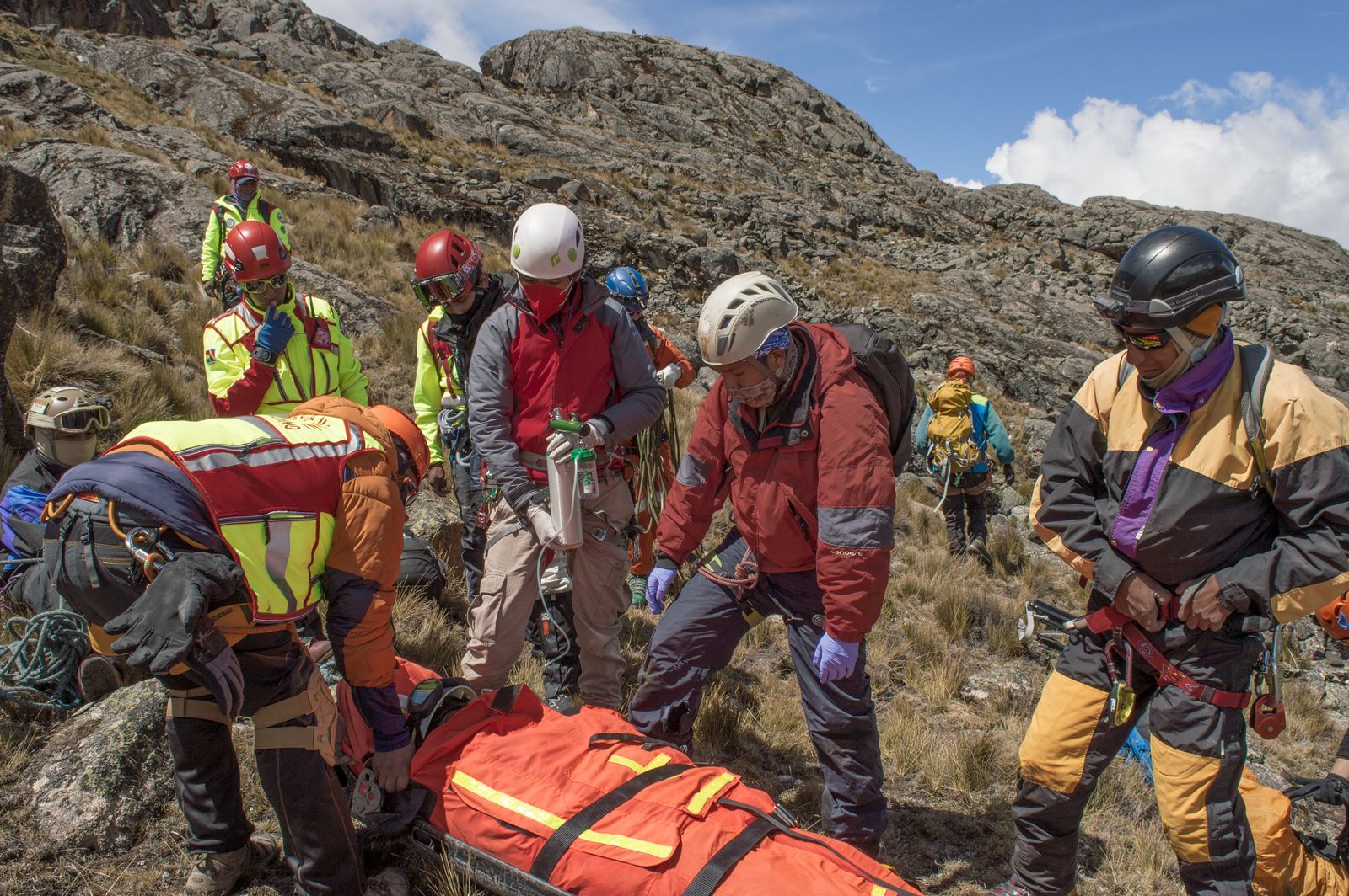 Search and rescue team aiding a person in rugged terrain